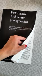 Abbildung der Dissertationsschrift, eine Hand blättert im Buch.