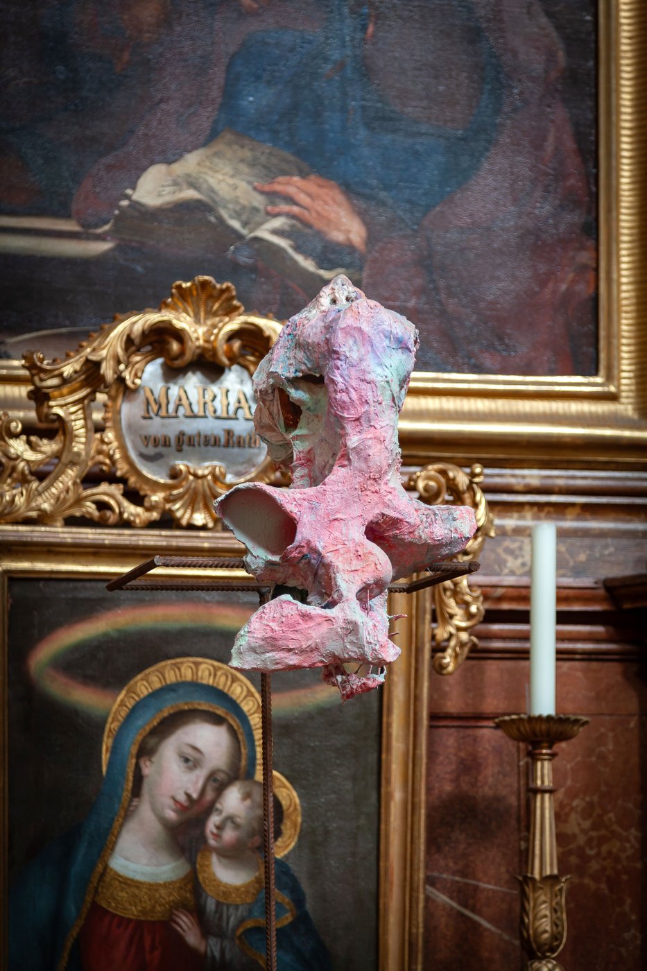 vor einem Kirchenbild ist eine hellrosa Installation palziert