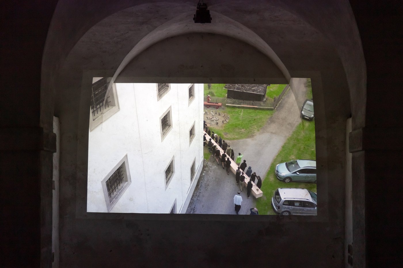 Videostill, das an eine Wand in einem Gewölberaum projeziert wird