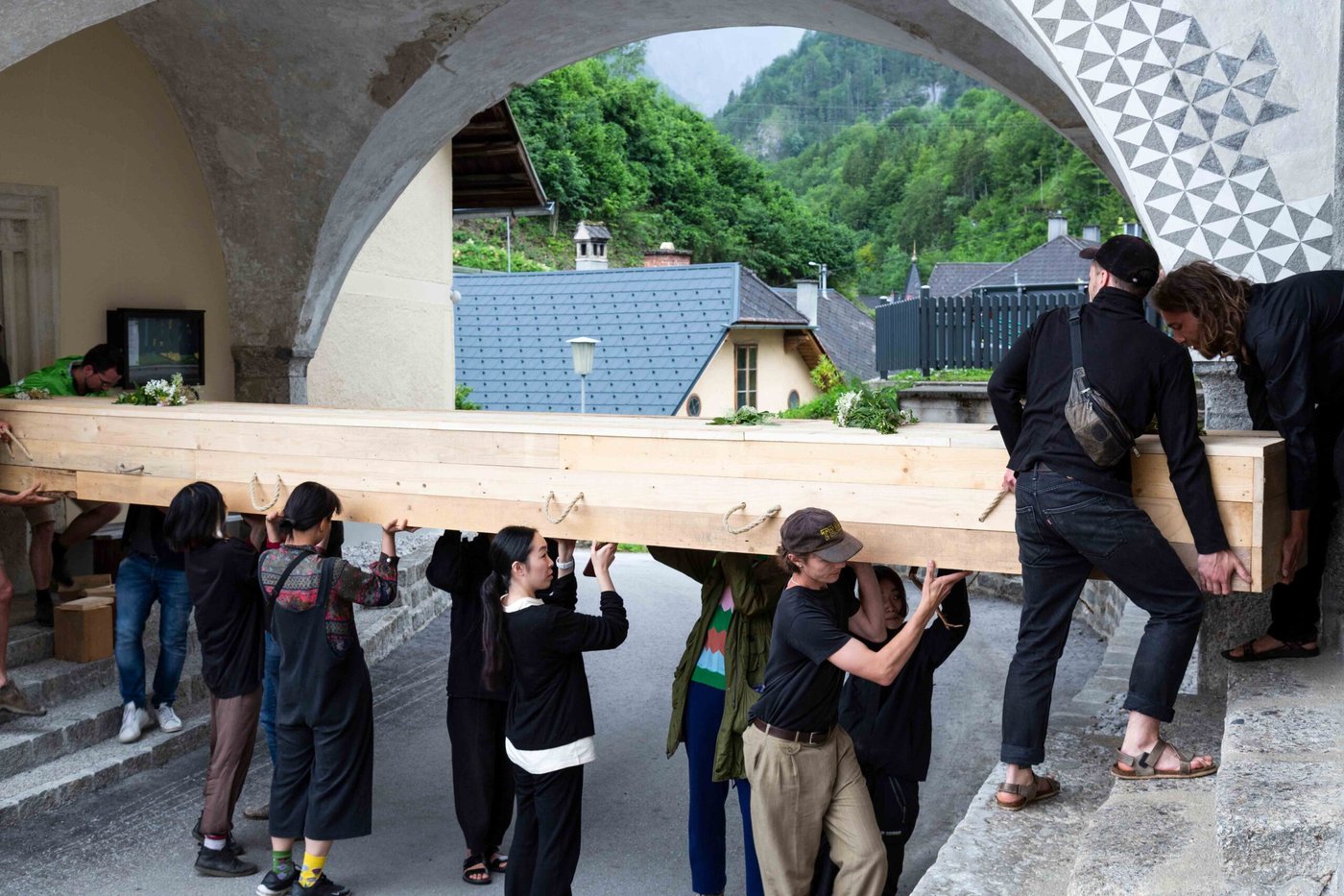 mehrere Personen tragen eine riesige Holzsarg auf ihren Schultern