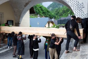 mehrere Personen tragen eine riesige Holzsarg auf ihren Schultern