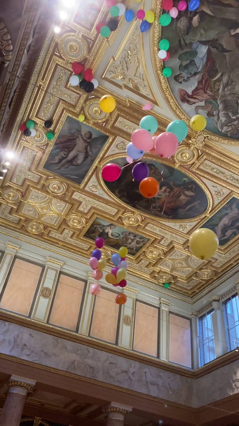 Luftballons fliegen an eine goldene Decke