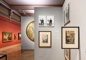 ein Ausstellungsraum mit Malerein an der Wand