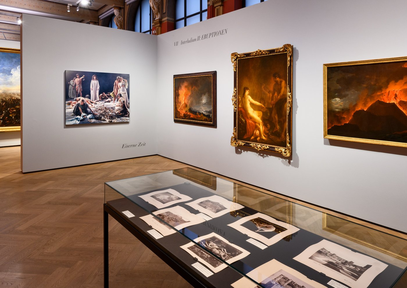 Ein Ausstellungsraum mit vielen bunten Gemälden an der Wand