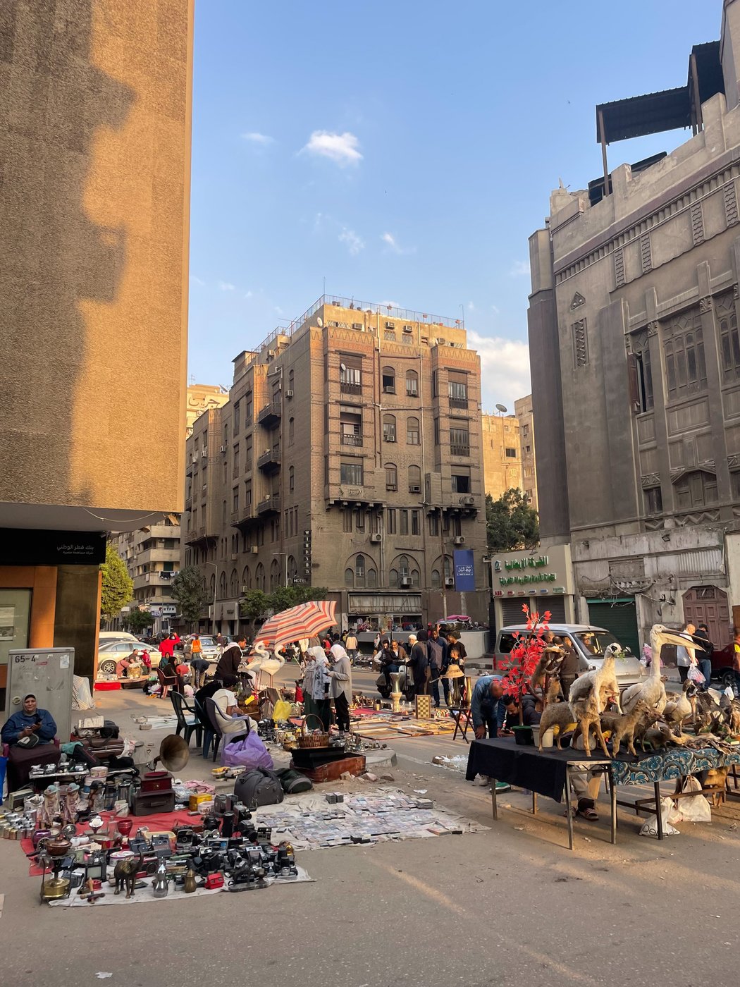 Aufnahme einer belebten Szene in den Straßen Kairos, auf einem Flohmarkt werden am Boden auf Decken Waren angeboten