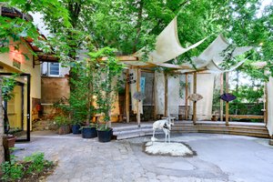 exhibition view in a green courtyard with artworks in the center