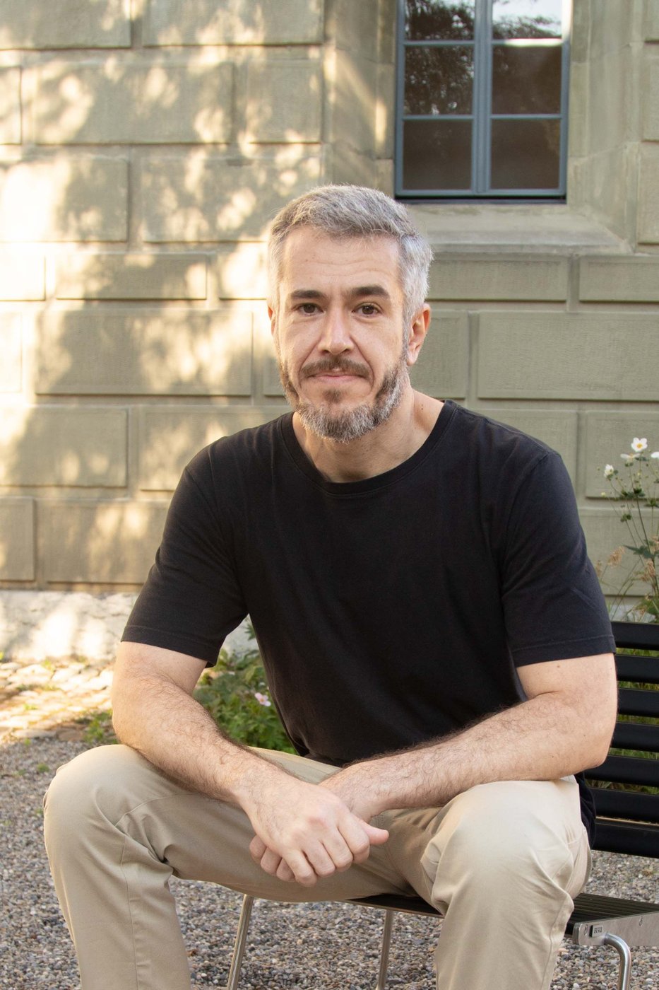 Person in front of a building sitting on a bench