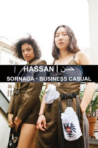 two models with pieces from the Sernaga Collection; brown jacket with belt and brown overall with straps as well as belt bags in white with double eagle application made of rhinestones;