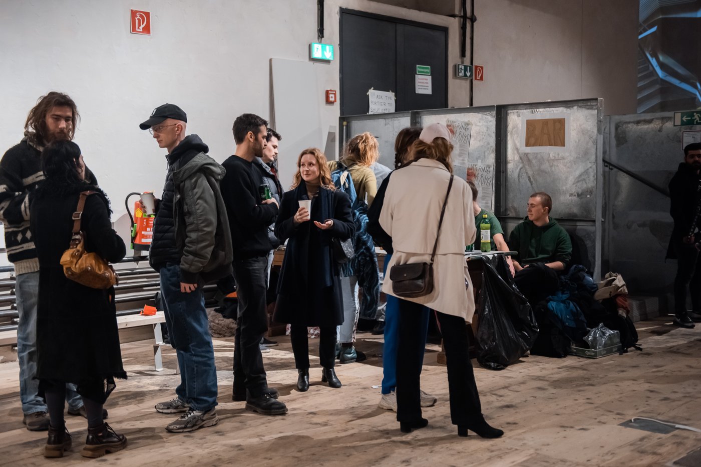 picture of people standing in a room and talking to each other