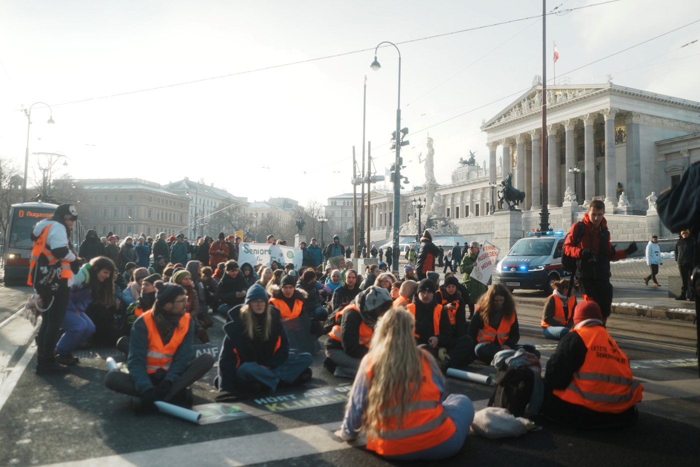 People sitting on the street with warning wests