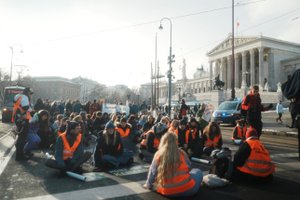 People sitting on the street with warning wests